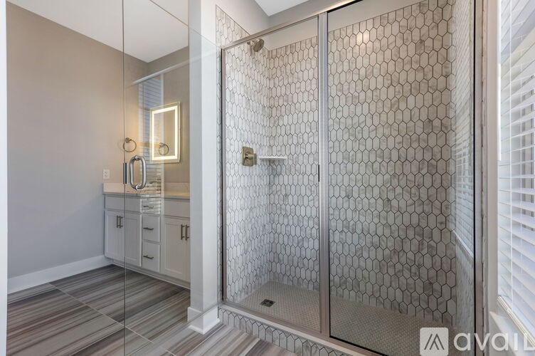A bathroom with a glass shower door and a glass wall.