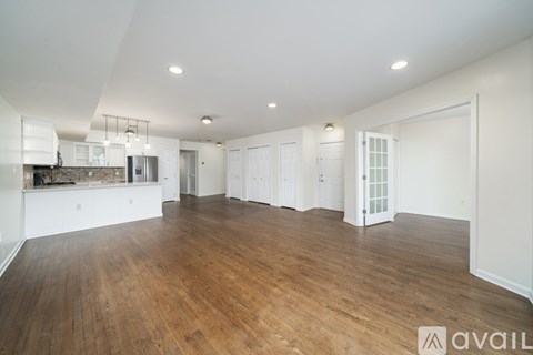 A spacious room with wooden floors and white walls.