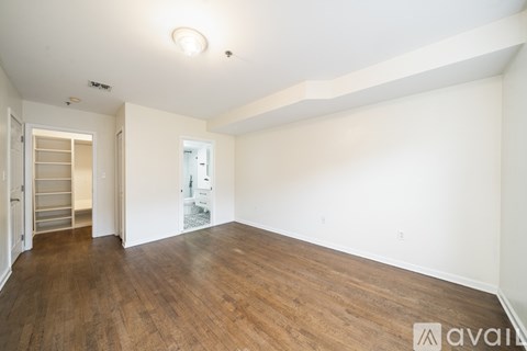 A large empty room with wooden floors and white walls.