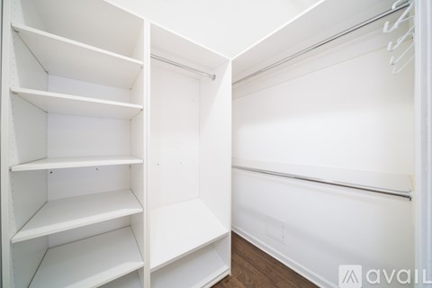 A white closet with shelves and a hanger rod.