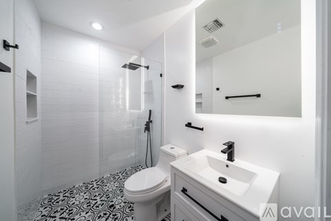 A bathroom with a toilet, sink, and shower.