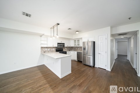 A kitchen with white cabinets and a wooden floor.