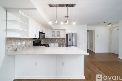 A kitchen with white cabinets and a stone backsplash.
