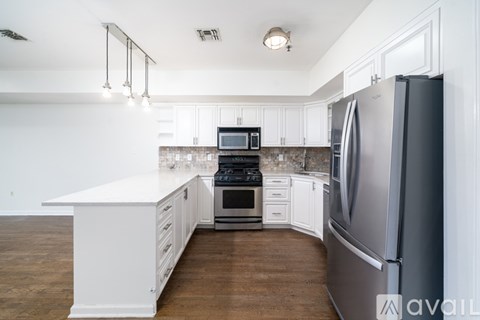 A kitchen with white cabinets and a wooden floor.