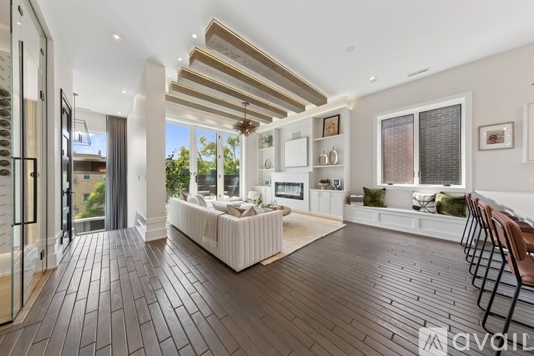 A spacious living room with a white sofa and wooden flooring.