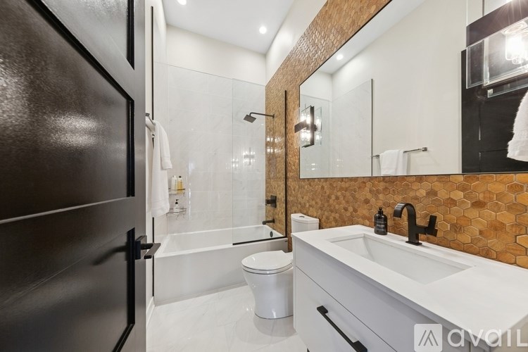 A modern bathroom with a toilet, sink, and shower.