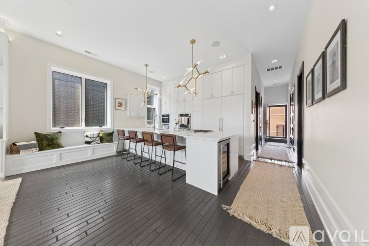 A modern kitchen with a dining area and a view of the hallway.