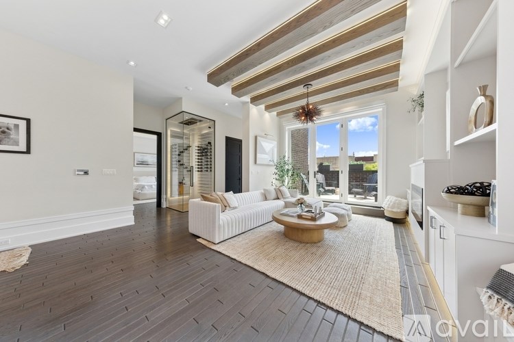 A spacious living room with a large window and a wooden floor.