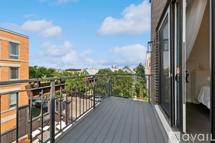 A balcony with a black railing and a wooden floor.