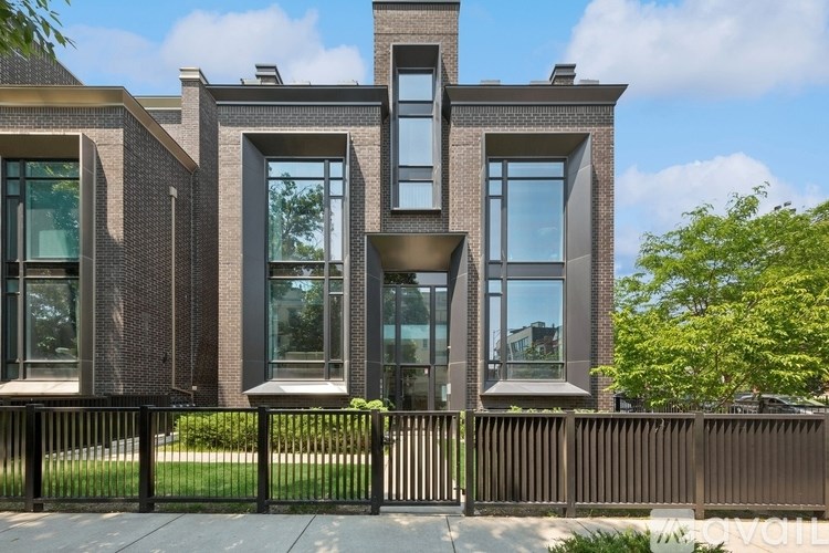 A modern house with a black fence in front.