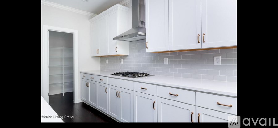 A kitchen with white cabinets and a tiled backsplash.