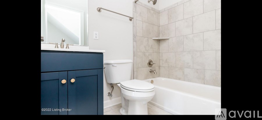 A white toilet sits next to a bathtub in a bathroom.
