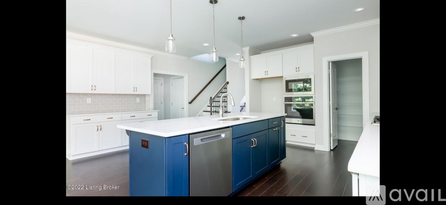 A kitchen with white cabinets and a blue island.