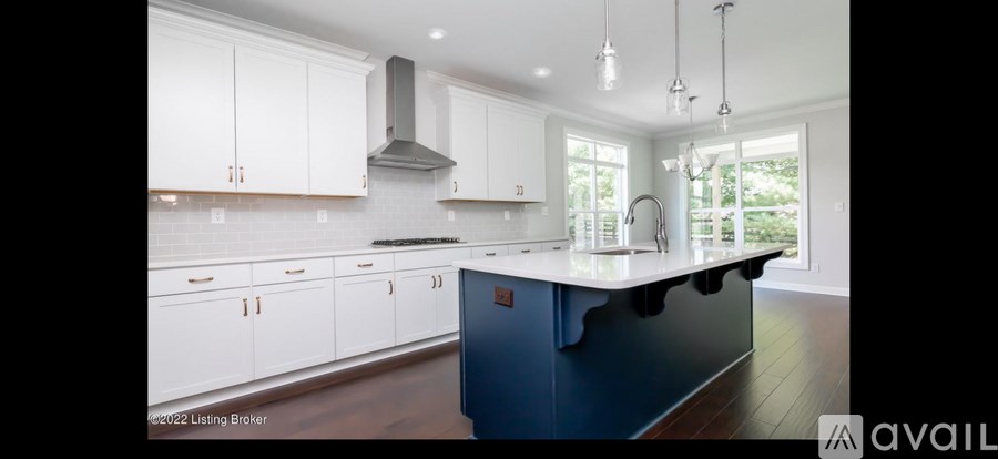 A kitchen with white cabinets and a blue island.