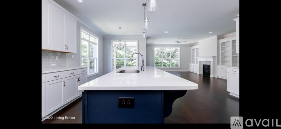 A kitchen with a blue island and white cabinets is for sale.