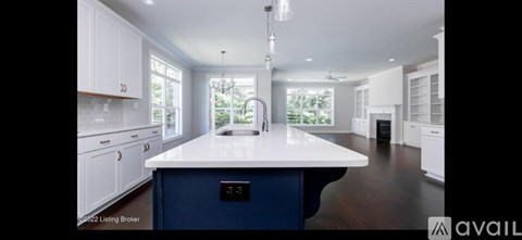 A kitchen with a blue island and white cabinets is for sale.