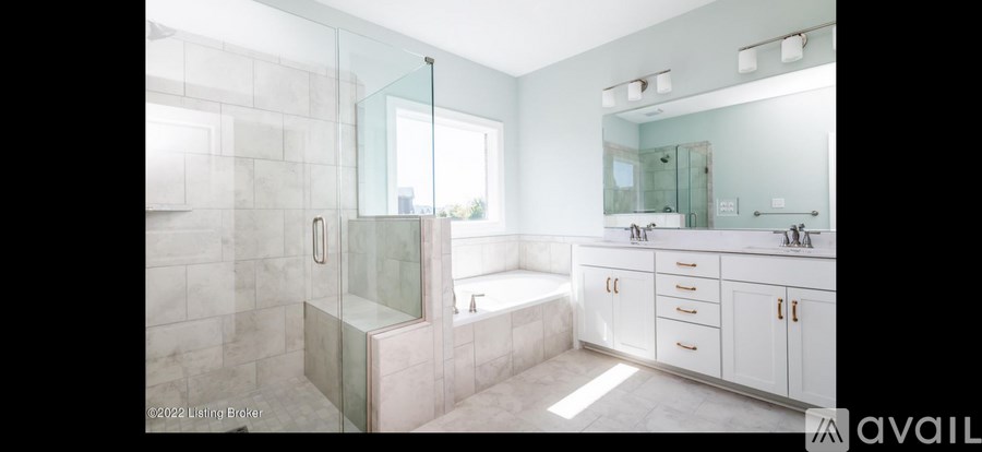 A bathroom with a glass shower door and a bathtub.