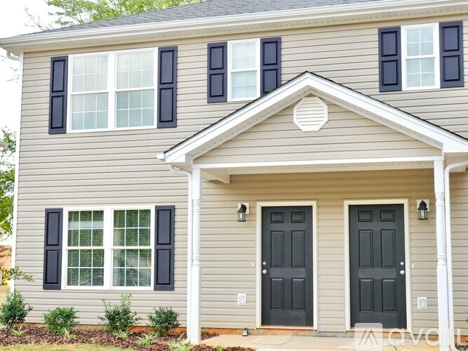 A house with a grey facade and black shutters.
