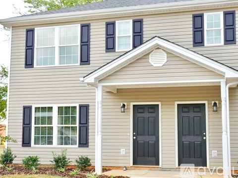 A house with a grey facade and black shutters.
