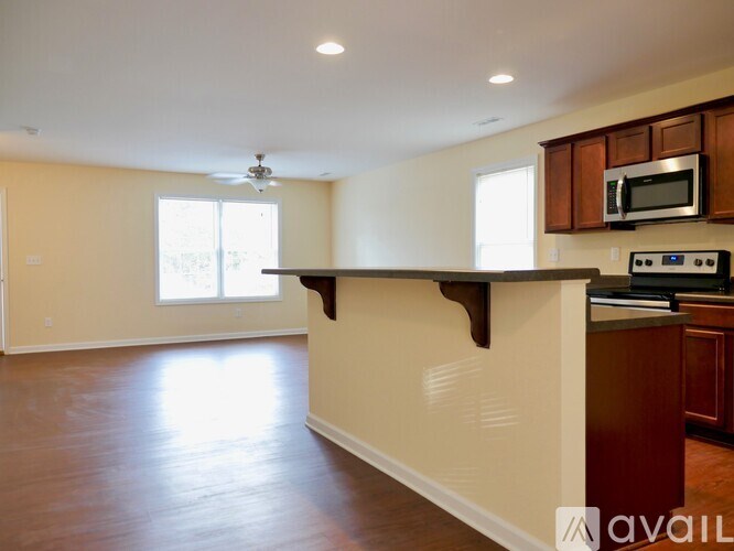A kitchen with wooden cabinets and a microwave above the stove.