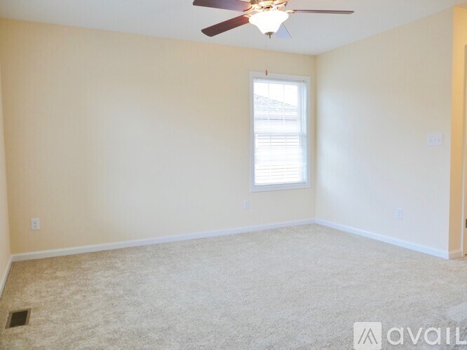 A room with a ceiling fan and a window.
