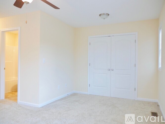 A room with a ceiling fan and two white doors.