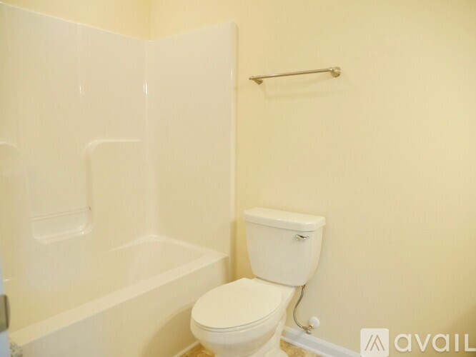 A white toilet sits next to a white bathtub in a bathroom.