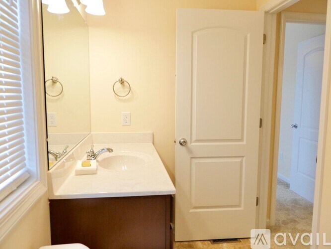 A bathroom with a white sink and a white door.