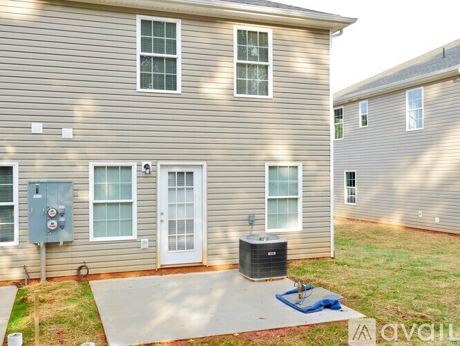A house with a grey siding and a white door is available for rent.