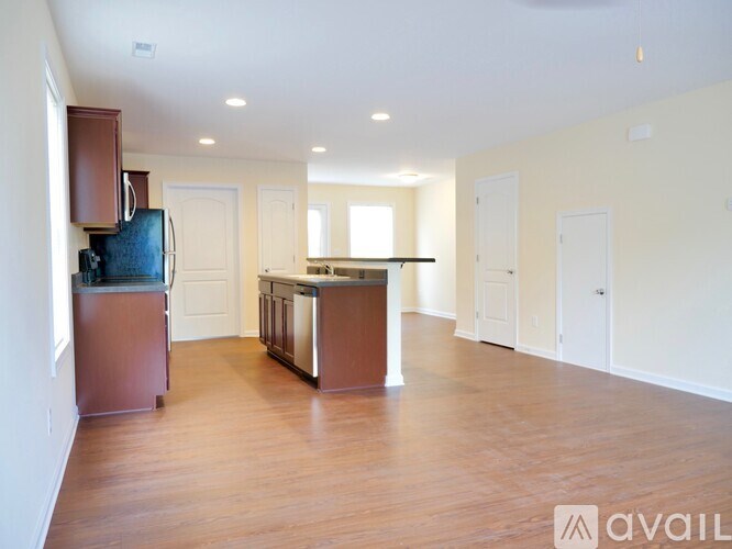 A kitchen with wooden floors and white walls is available for rent.