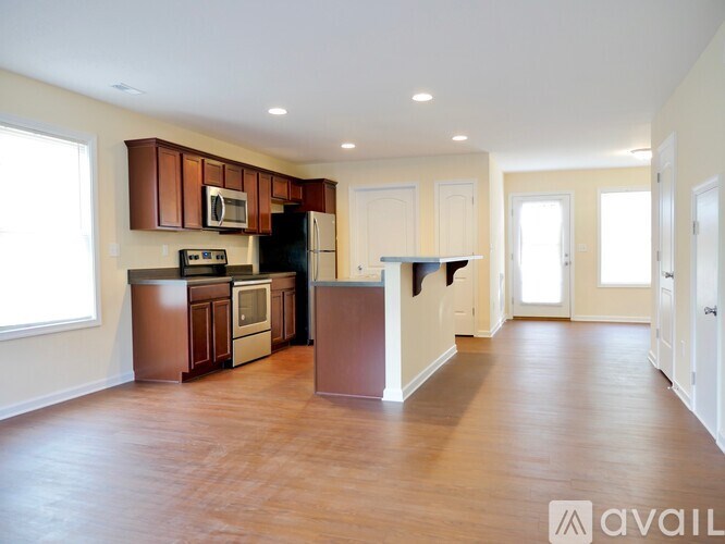A kitchen with brown cabinets and a black refrigerator.