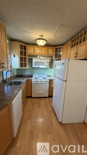 A kitchen with wooden cabinets and a white refrigerator.