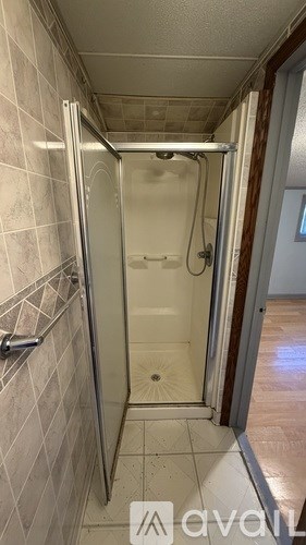A bathroom with a walk-in shower and tiled walls.