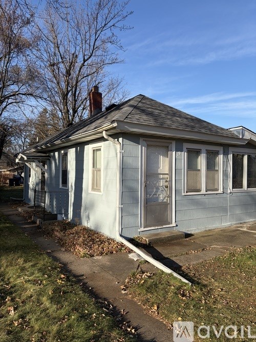A small house with a grey roof and a blue exterior is shown.