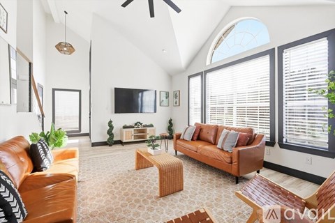 A living room with a brown leather couch and a wooden coffee table.