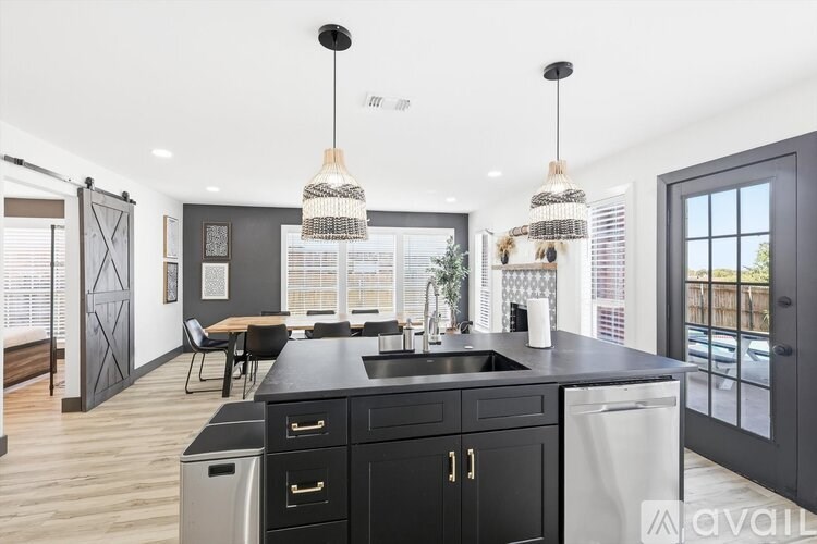 A modern kitchen with black cabinets and a large island.