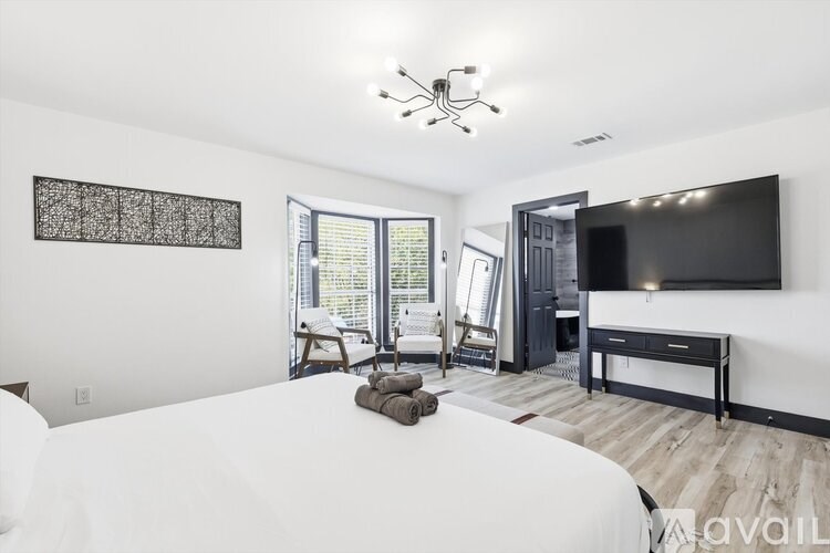 A bedroom with a large bed and a flat screen TV mounted on the wall.