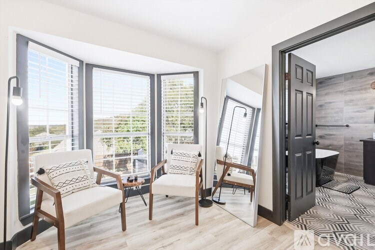 A living room with a couch, chairs, and a large mirror.