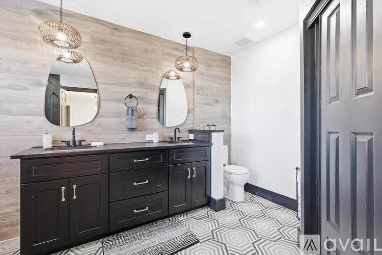 A bathroom with a wooden wall and a black door.