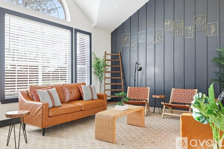 A living room with a brown couch, a wicker coffee table, and a wooden chair.