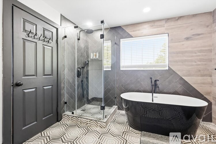 A modern bathroom with a black and white patterned floor.