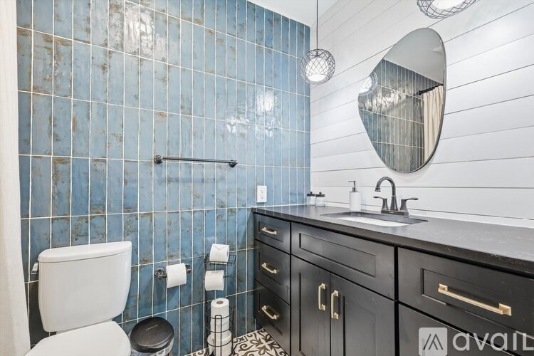 A bathroom with a toilet, sink, and mirror.