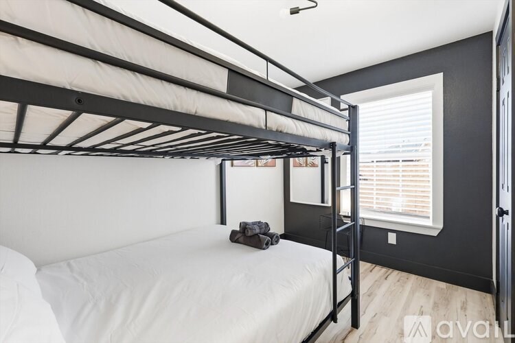 A white bed with a black metal frame in a room with a window.