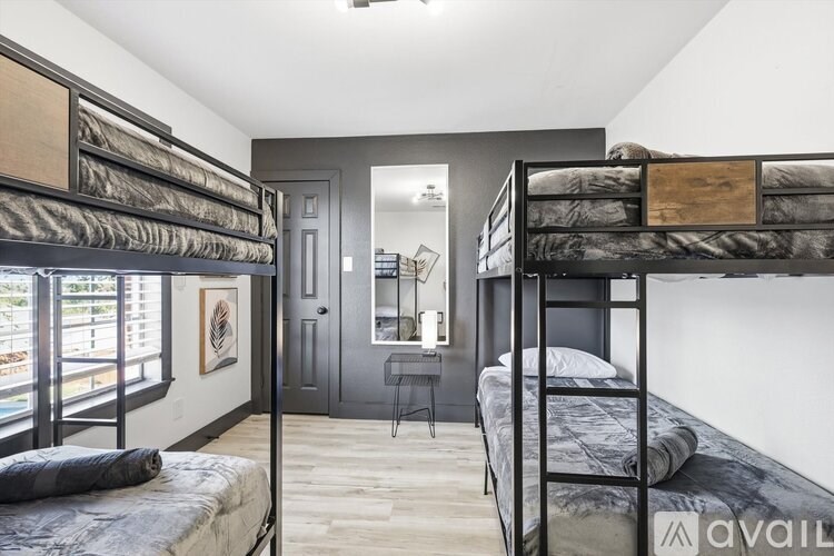 A bedroom with two bunk beds and a desk.