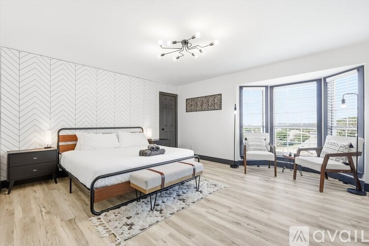 A bedroom with a large bed and a ceiling fan.