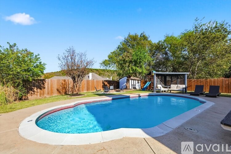 A backyard with a pool and a gazebo.