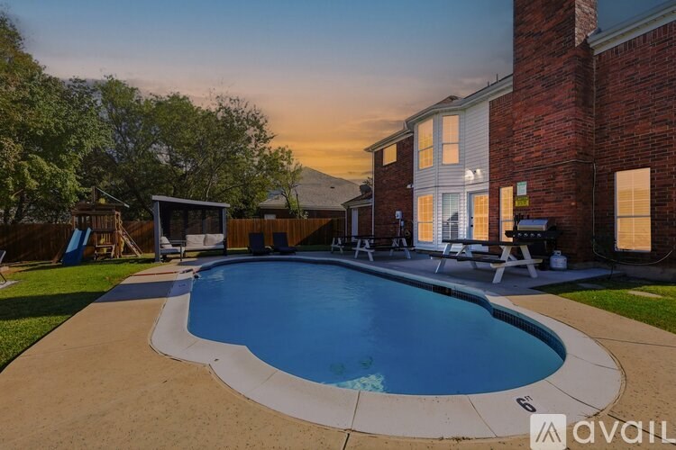 A backyard with a pool and a house.