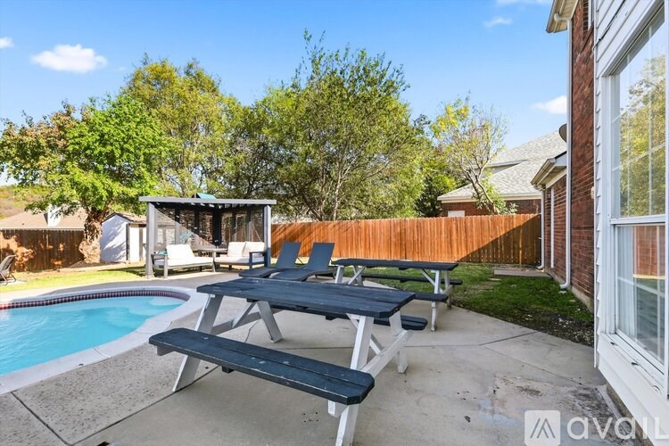 A backyard with a picnic table and a pool.