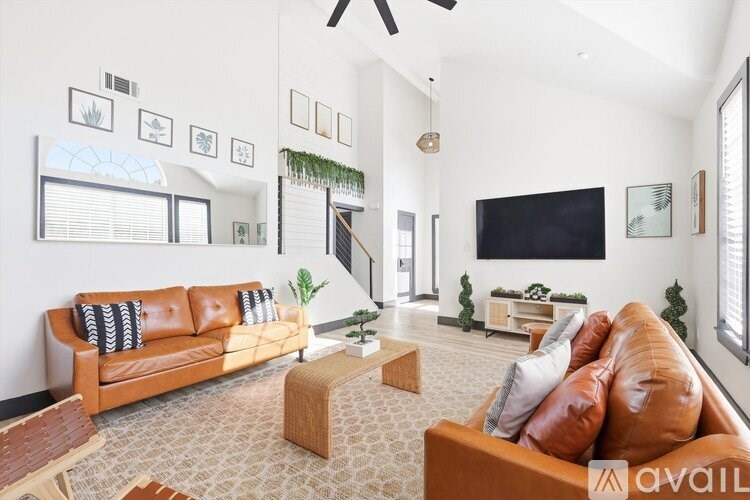 A living room with a brown leather couch and a wooden coffee table.