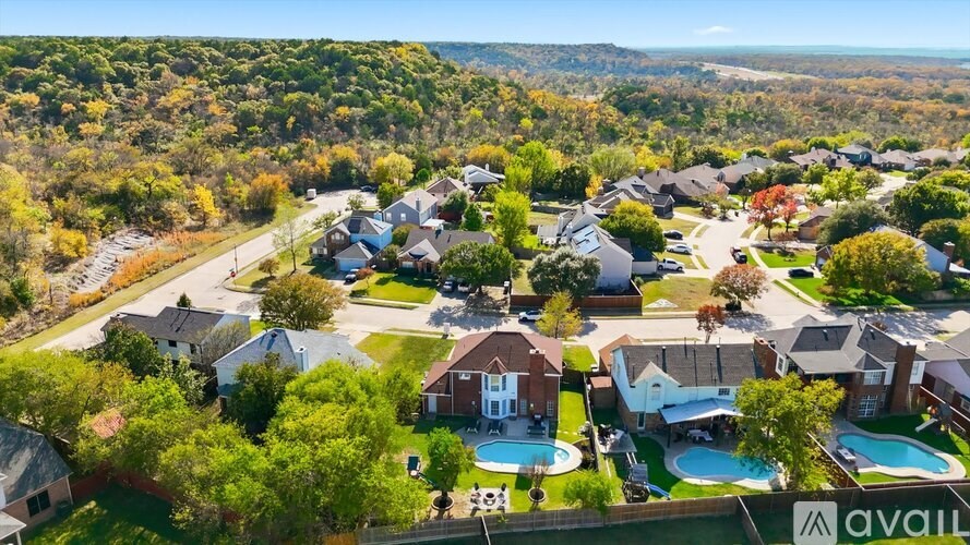 A bird's eye view of a suburban neighborhood with houses and swimming pools.